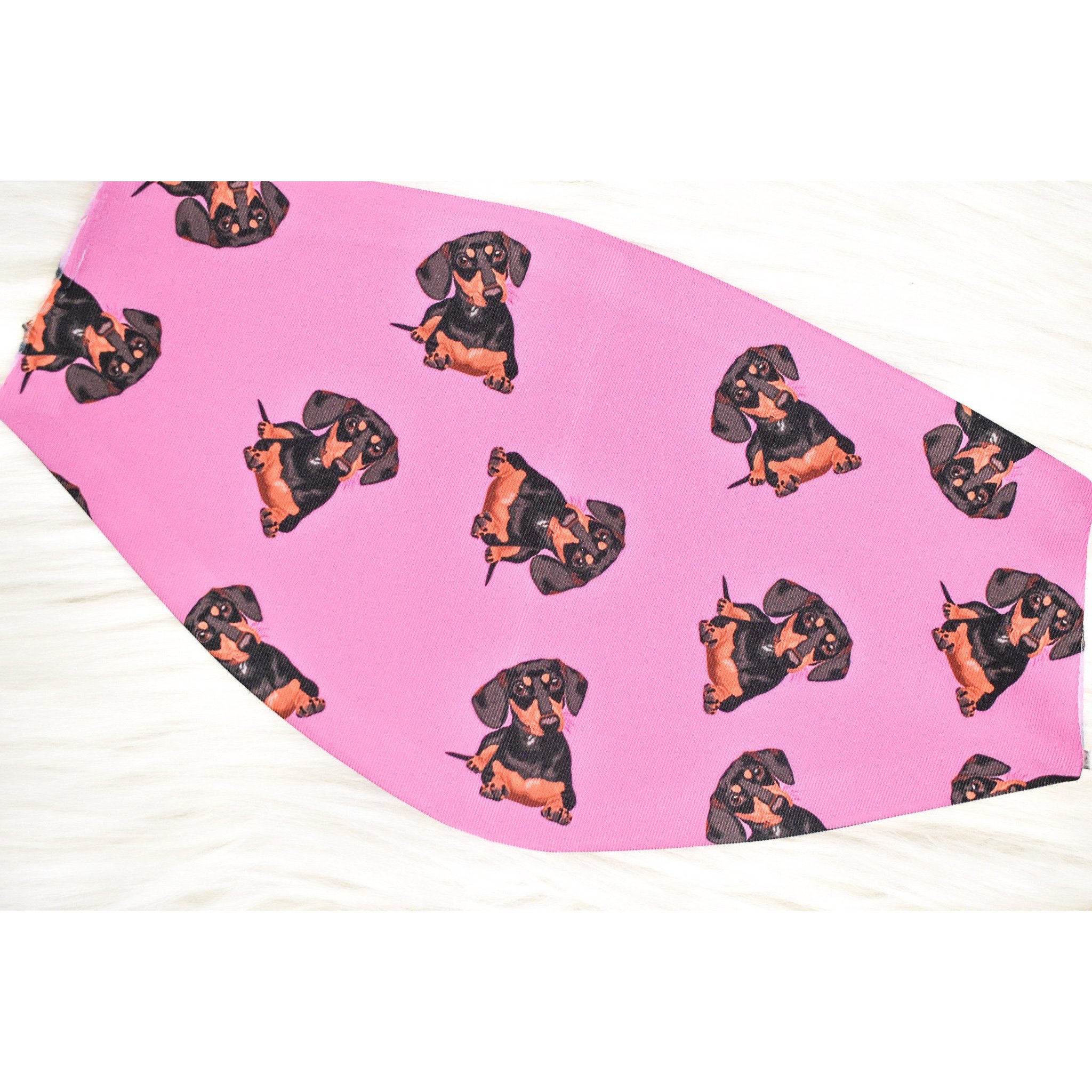 A stylish black and tan dachshund face cover, handmade with breathable fabric, showcasing a cute dog print.
