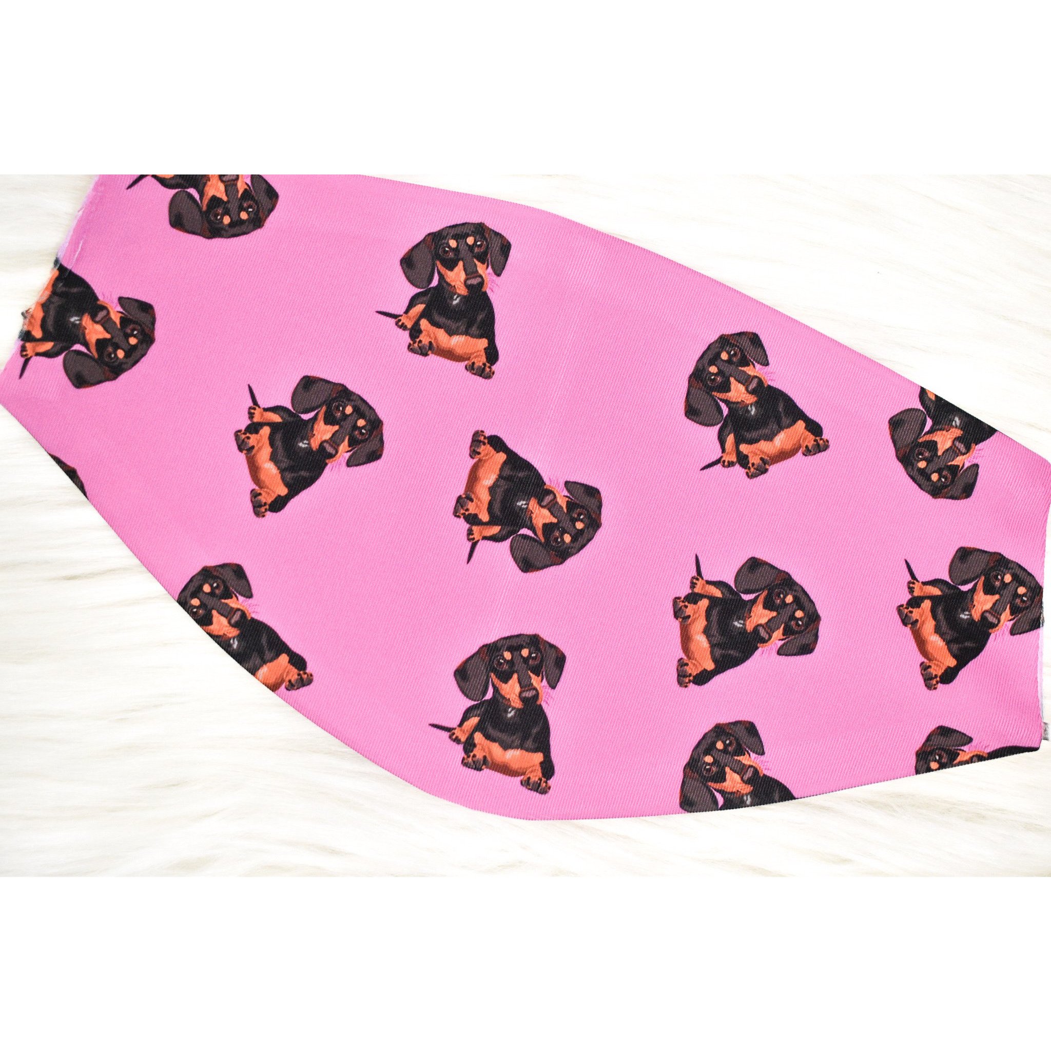 A stylish black and tan dachshund face cover, handmade with breathable fabric, showcasing a cute dog print.