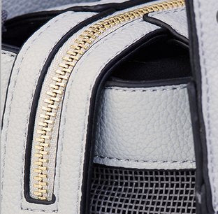 Designer grey vegan leather pet carrier with mesh windows and removable lining, suitable for small dogs and cats.