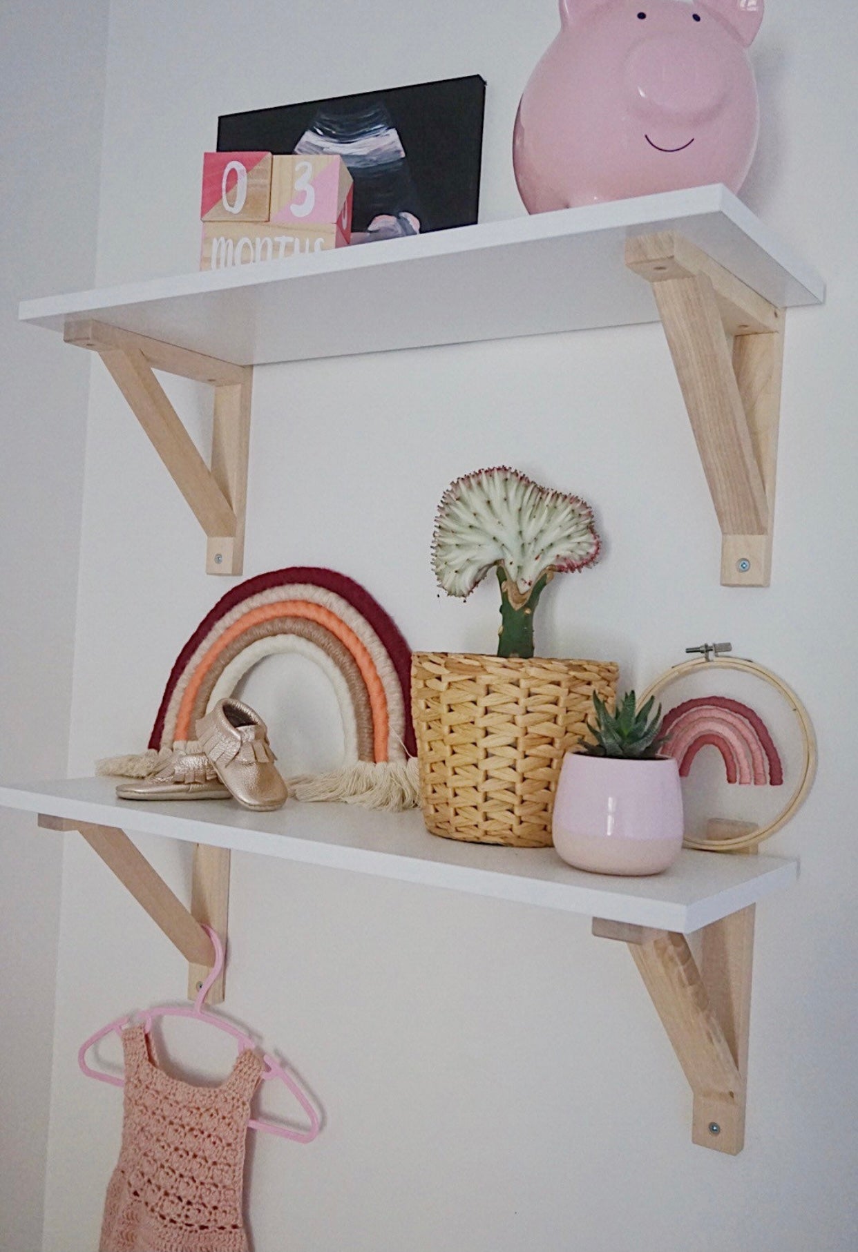 A colorful handmade rope rainbow wall hanging, featuring vibrant hues and a chunky design, perfect for nursery decor.