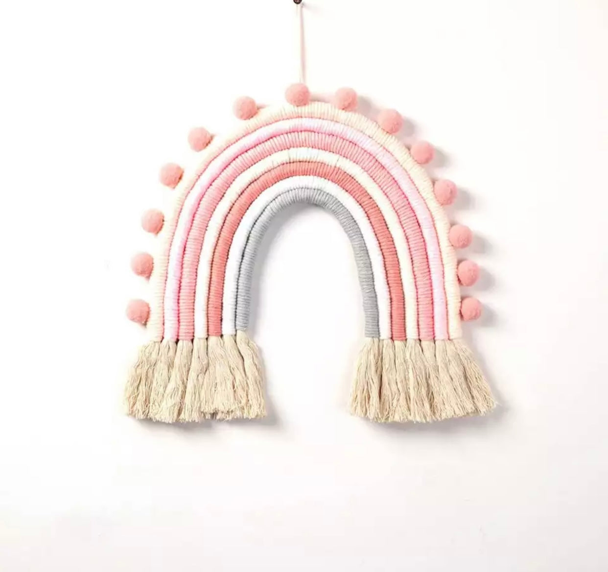 A colorful handmade rope rainbow wall hanging, featuring vibrant hues and a chunky design, perfect for nursery decor.
