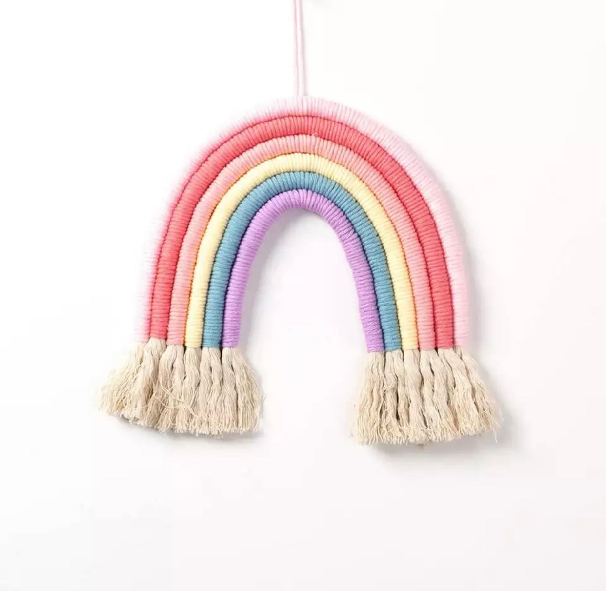 A colorful handmade rope rainbow wall hanging, featuring vibrant hues and a chunky design, perfect for nursery decor.