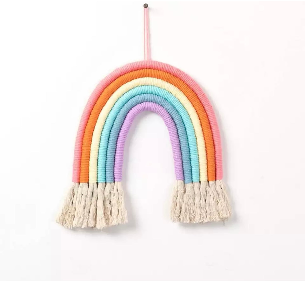 A colorful handmade rope rainbow wall hanging, featuring vibrant hues and a chunky design, perfect for nursery decor.