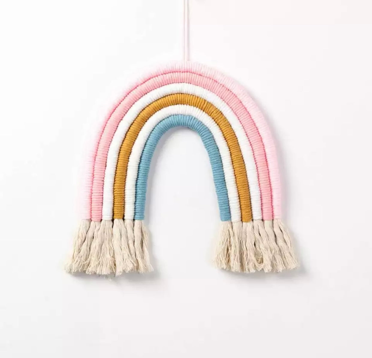 A colorful handmade rope rainbow wall hanging, featuring vibrant hues and a chunky design, perfect for nursery decor.