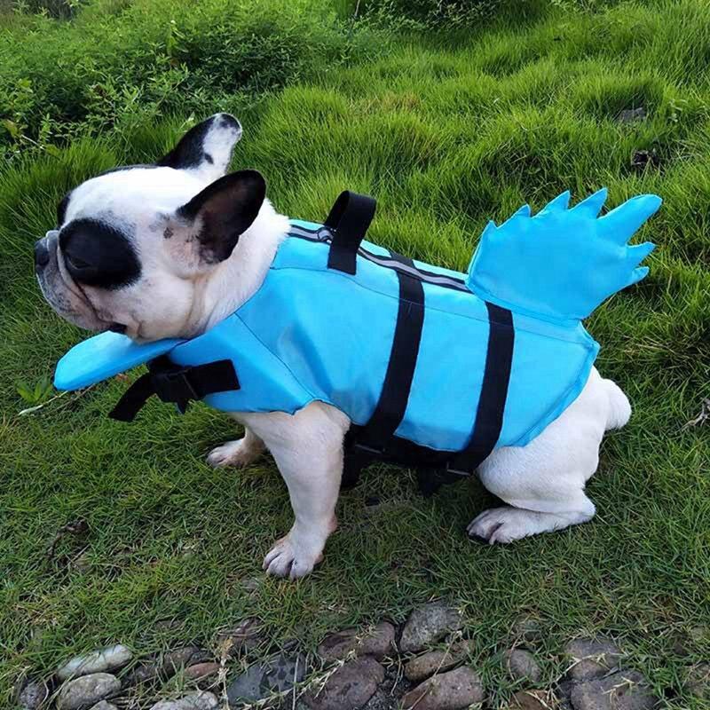 A vibrant shark-themed dog life vest designed for swimming, featuring adjustable straps and a sturdy handle for safety.