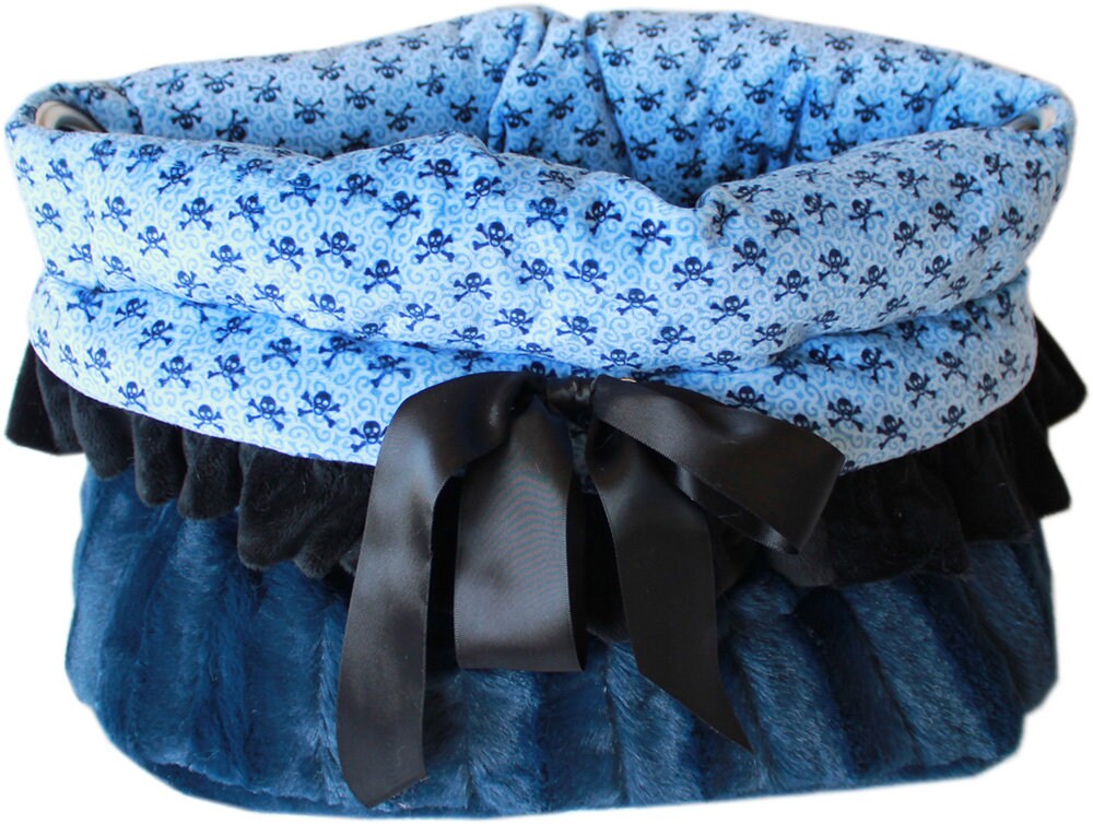 Reversible Snuggle Bugs Pet Bed in light pink and baby blue skulls, featuring a cozy design for dogs and cats, with a matching blanket and cushion.