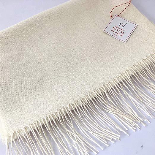 Luxurious white shawl made from 70% baby alpaca and 30% silk, showcasing its soft texture and elegant design.