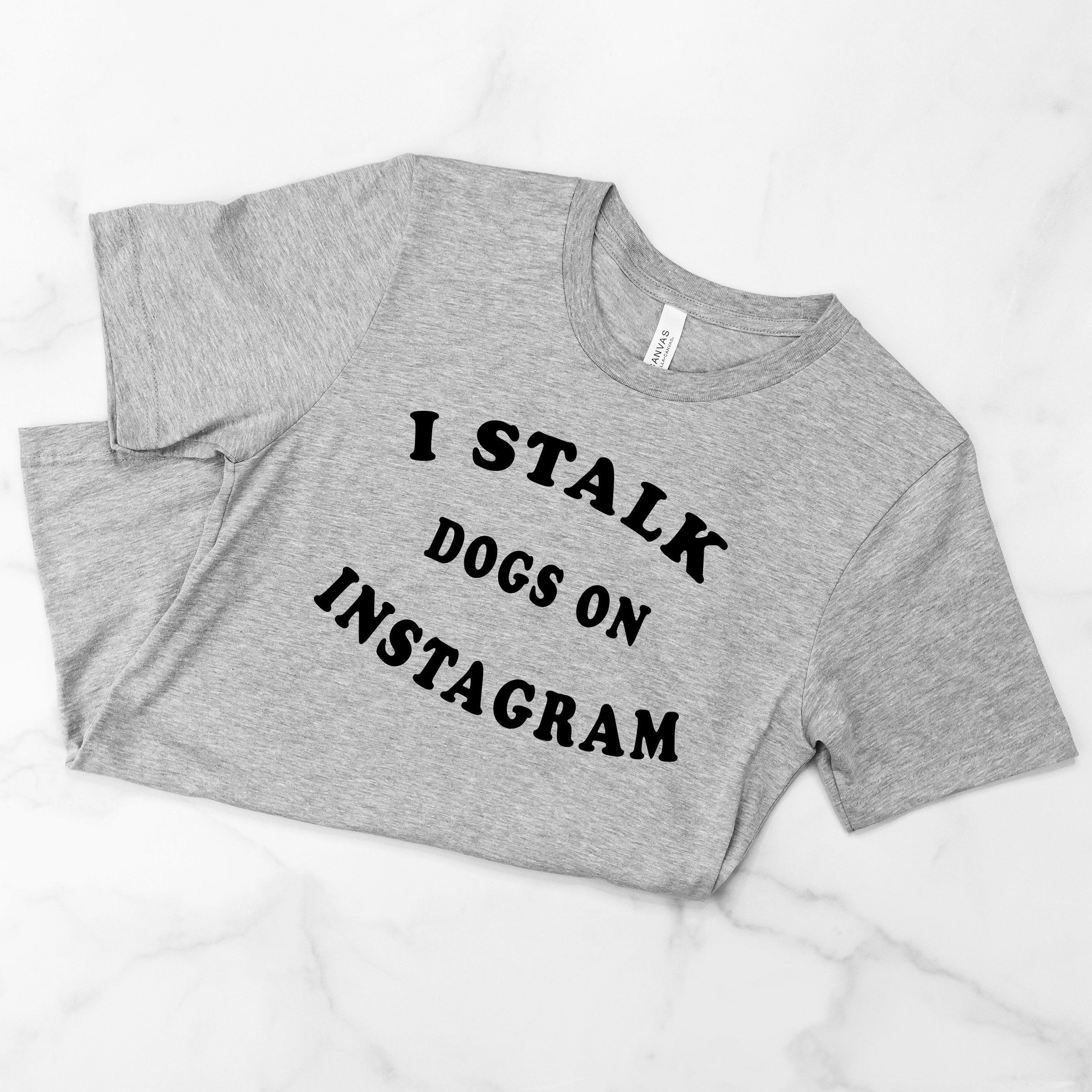 A soft crew neck tee featuring the quote 'I Stalk Dogs on Instagram', perfect for dog lovers.