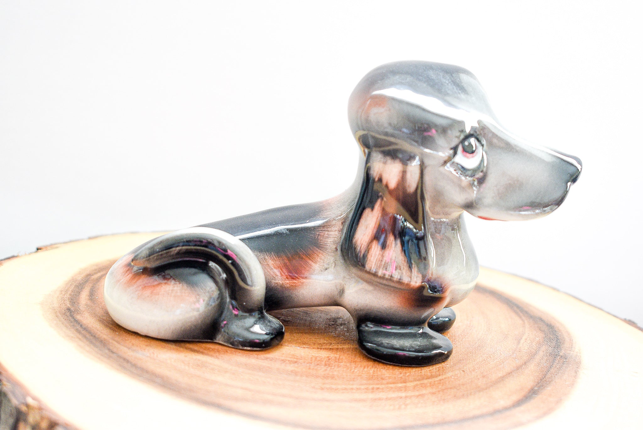 Vintage J. W. Co. Dachshund figurine made of porcelain, approximately 5 inches tall, showcasing intricate details and craftsmanship.