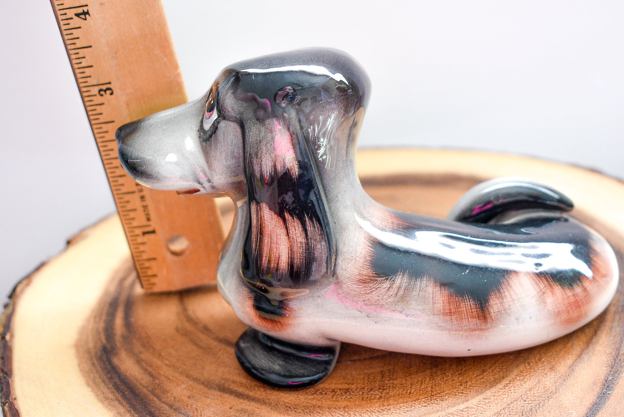 Vintage J. W. Co. Dachshund figurine made of porcelain, approximately 5 inches tall, showcasing intricate details and craftsmanship.