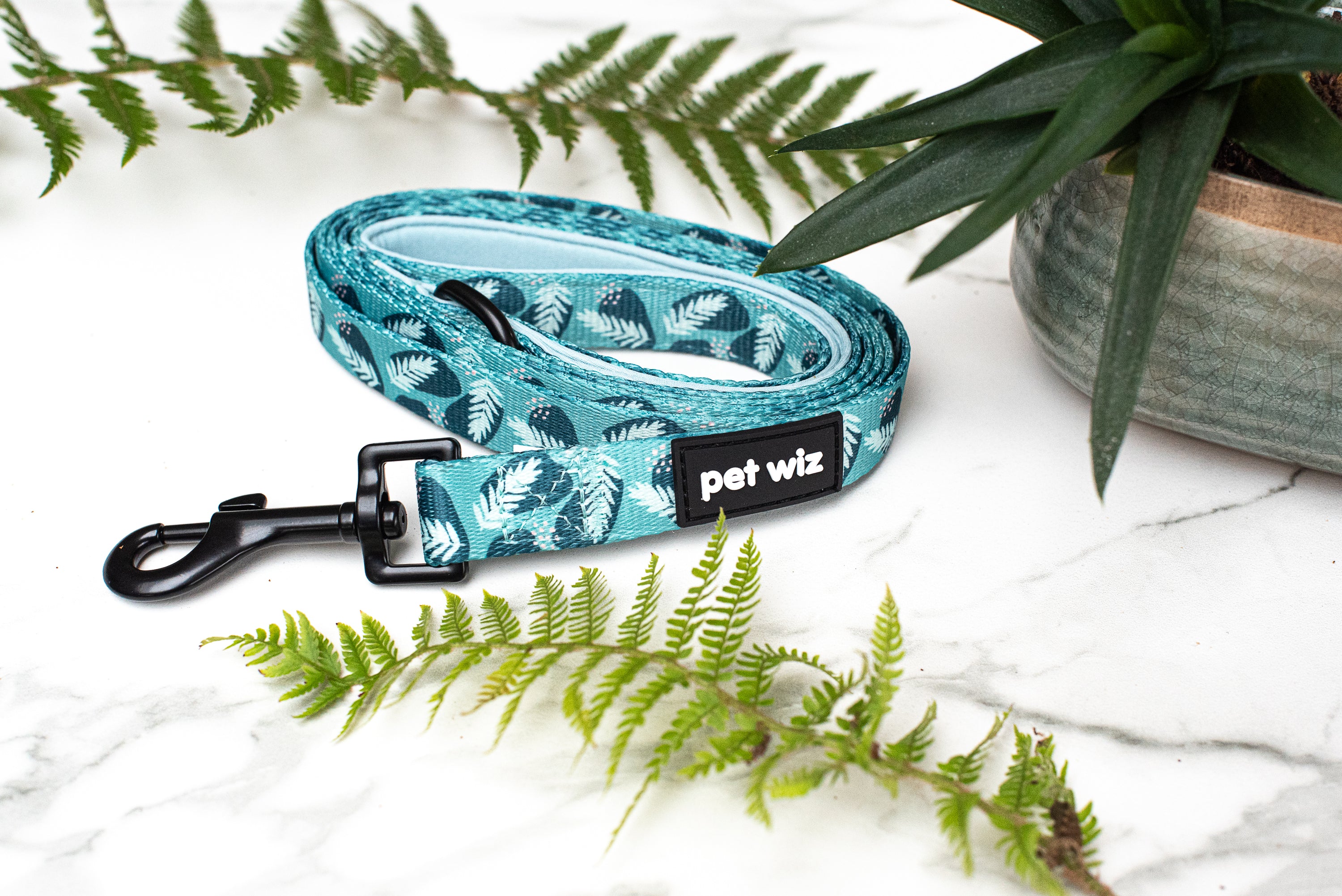A vibrant jungle-themed dog lead featuring three unique patterns, showcasing its neoprene padded handle and durable swivel clip.