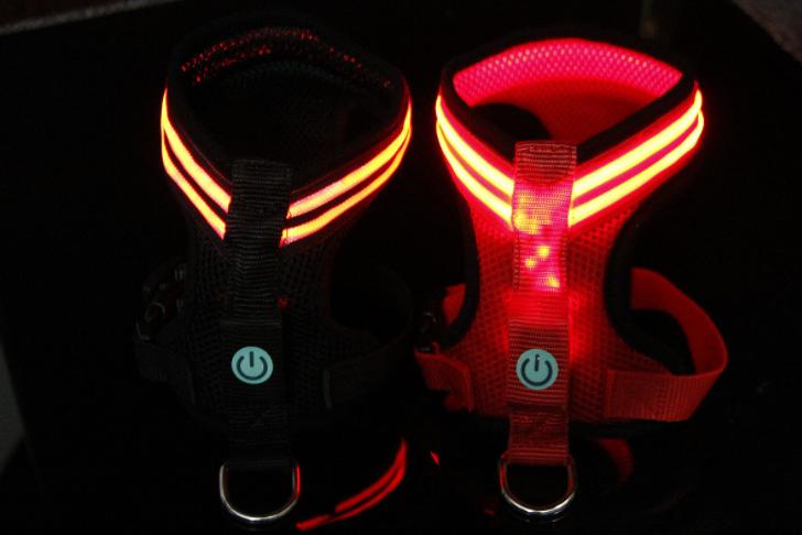 A brightly colored LED dog harness featuring optic fiber lights, adjustable straps, and a durable design, perfect for nighttime visibility.