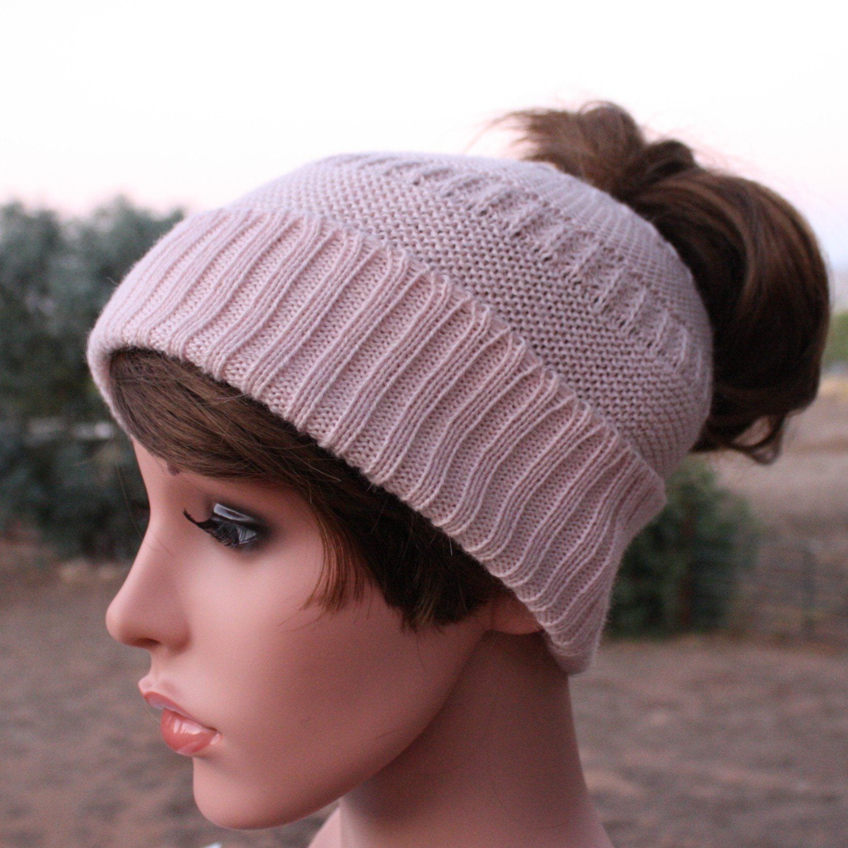 A cozy Messy Bun Alpaca Hat showcasing a stylish design with a ponytail hole, made from a soft alpaca blend, perfect for cool weather.
