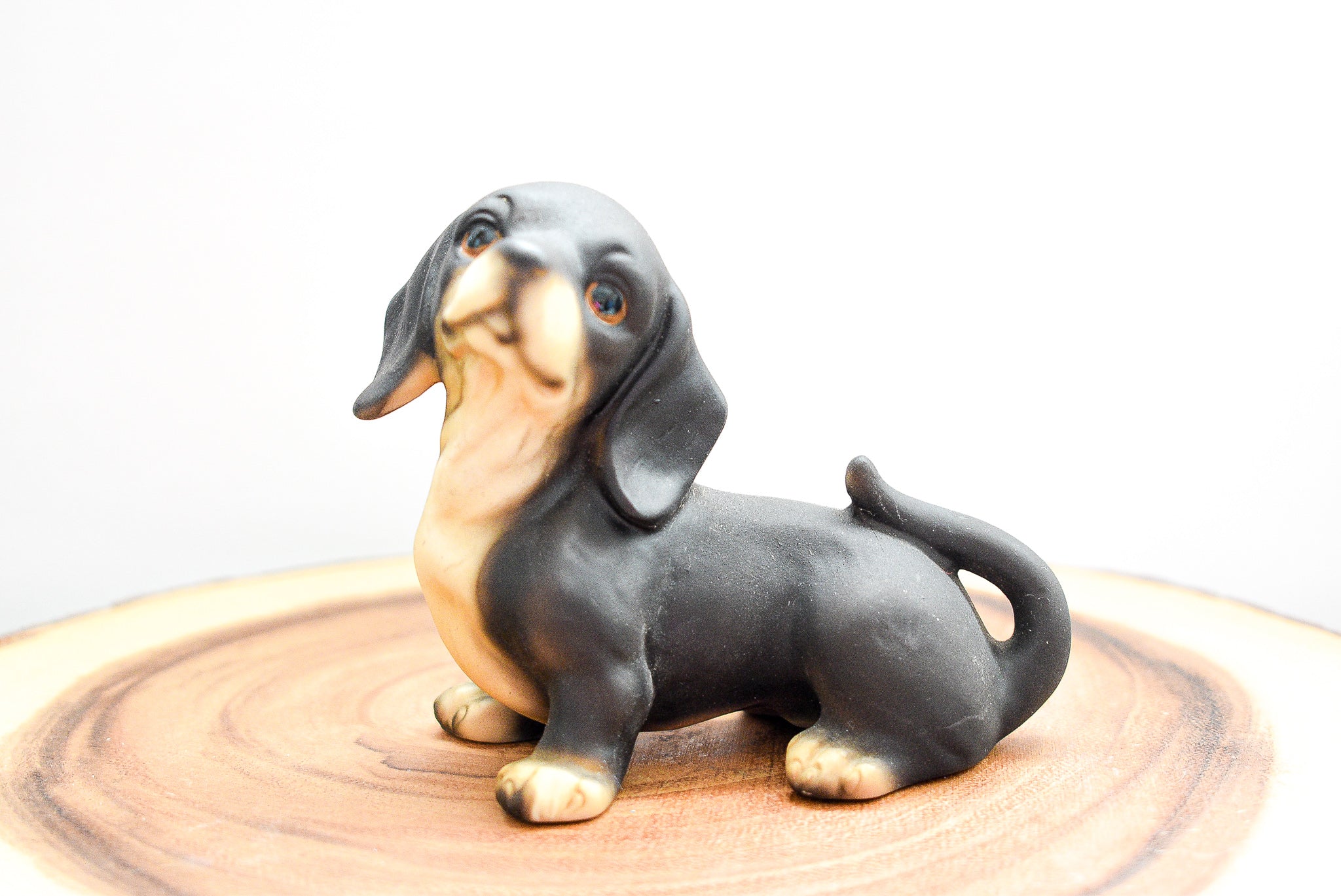 A detailed MSR Imports Dachshund figurine made of porcelain, showcasing intricate craftsmanship and a charming design.