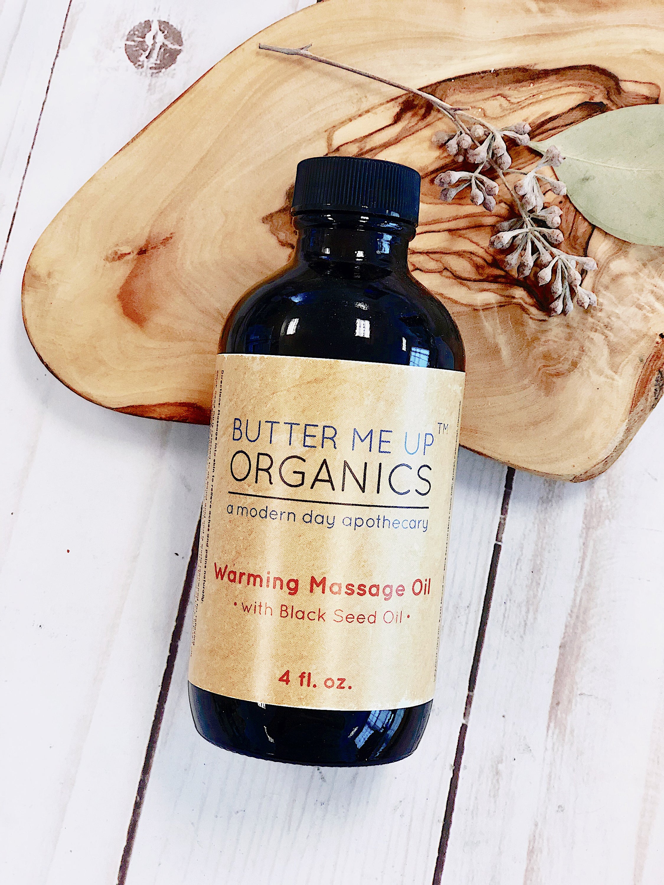 A 4oz glass bottle of Organic Warming Massage Oil with a soothing blend of natural ingredients for muscle relief.