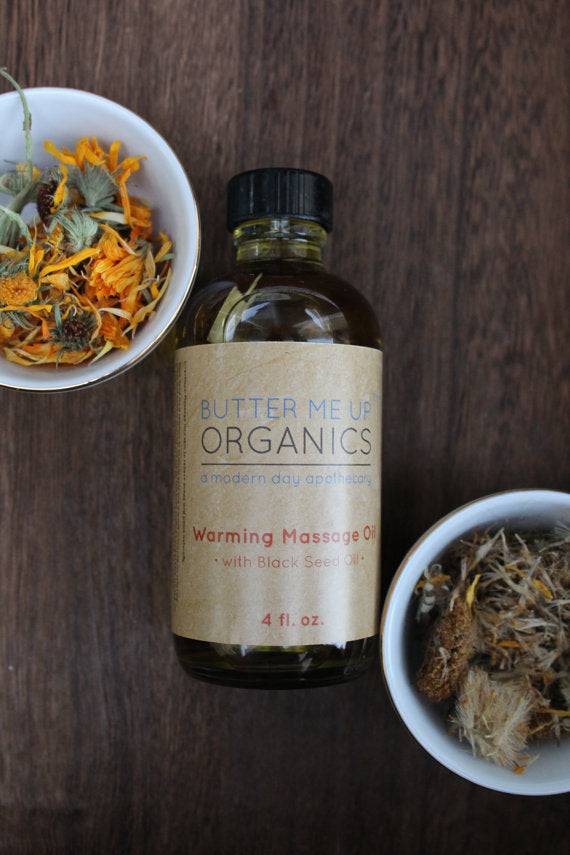 A 4oz glass bottle of Organic Warming Massage Oil with a soothing blend of natural ingredients for muscle relief.