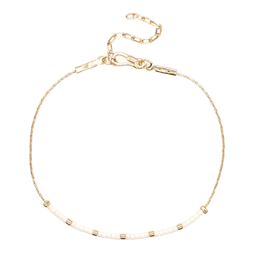 Delicate gold double-strand bracelet with colorful beads, featuring a lobster claw closure.