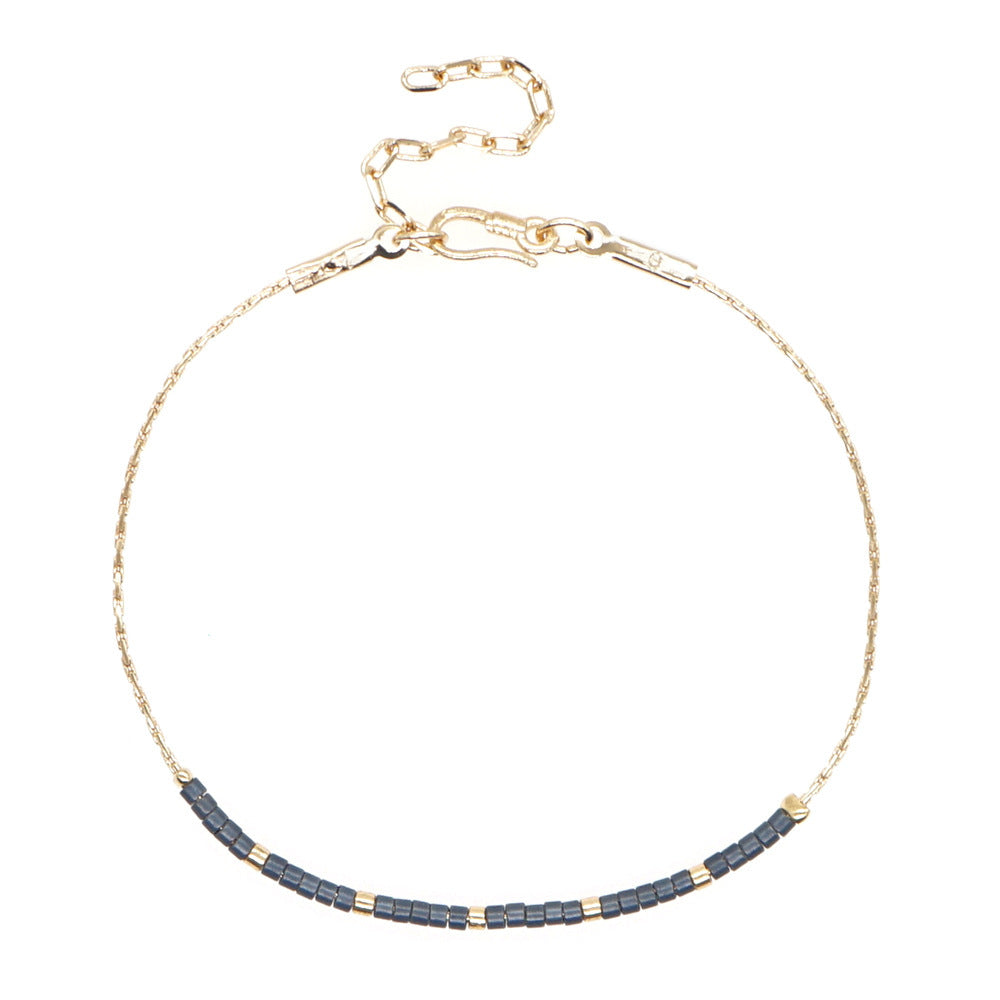 Delicate gold double-strand bracelet with colorful beaded accents, featuring a lobster claw closure, perfect for minimalist style.