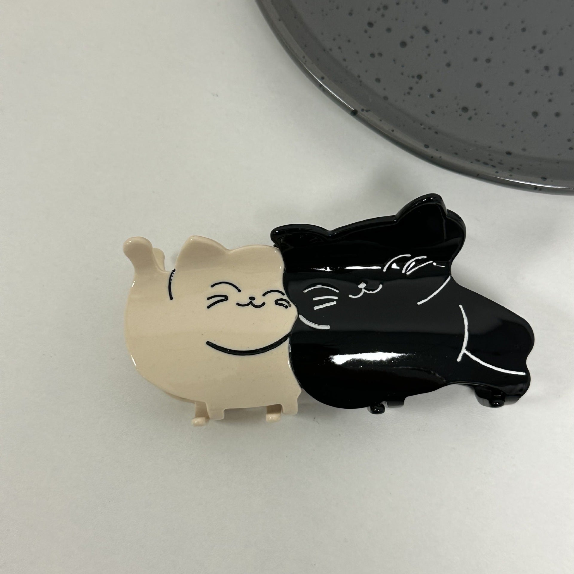 Hand-painted claw hair clip featuring a pug design, made from eco-friendly cellulose acetate, showcasing a unique and stylish accessory for pet lovers.