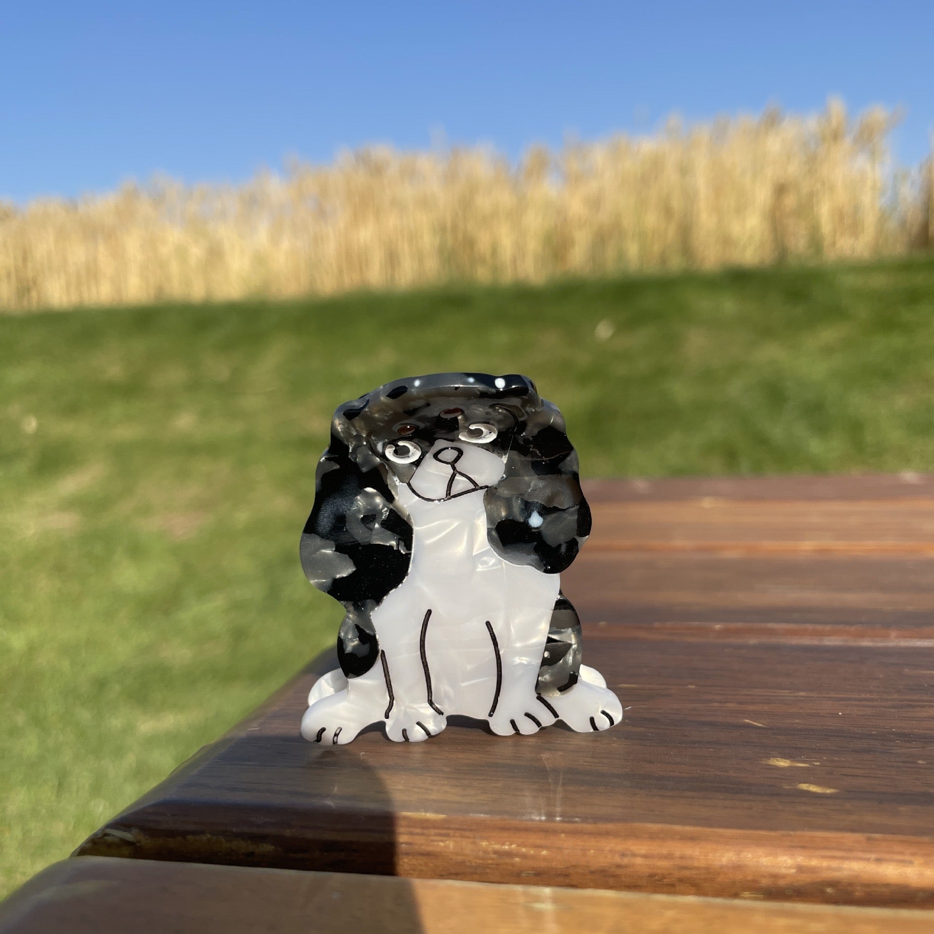 Hand-painted claw hair clip featuring a Pug design, made from eco-friendly cellulose acetate.