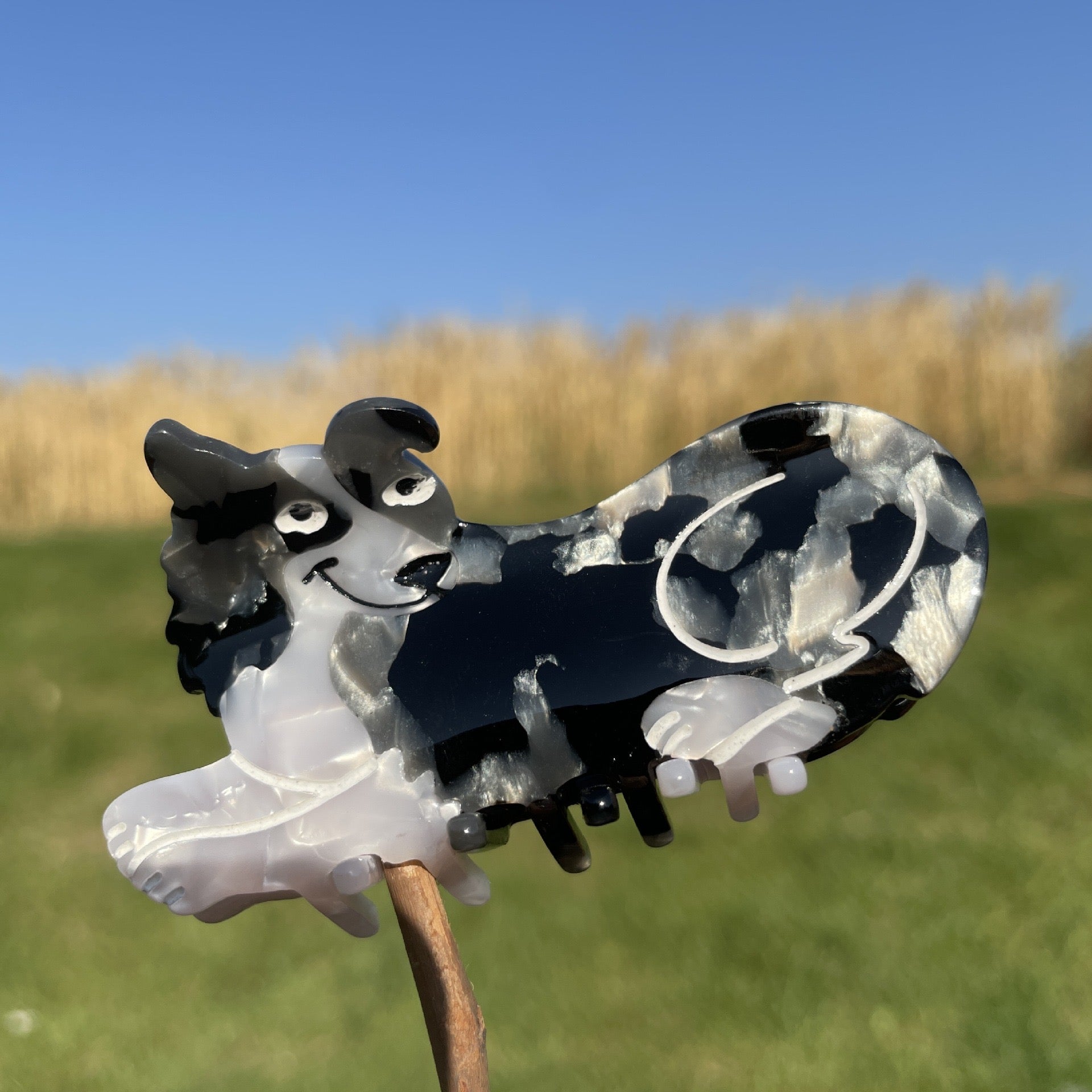 Hand-painted claw hair clip featuring a Pug design, made from eco-friendly cellulose acetate.