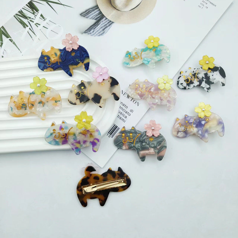 Hand-painted floral cat hair clip featuring colorful acetate and sparkling rhinestones, perfect for cat lovers.