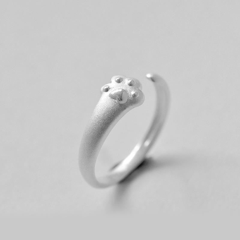 Adjustable sterling silver ring featuring cat ears and paw prints, perfect for pet lovers.