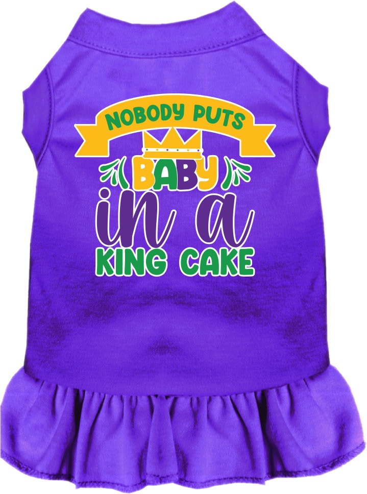 A medium to large pet wearing a stylish screen printed dress with ruffles, featuring the phrase 'Nobody Puts Baby In A King Cake'.