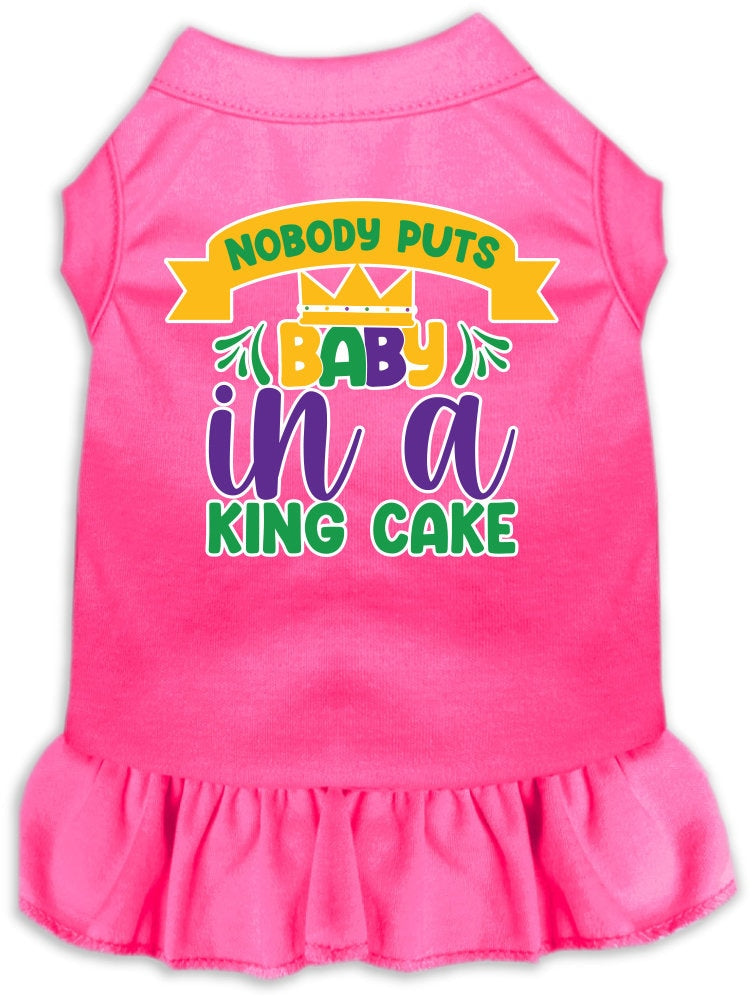 A medium to large pet wearing a stylish screen printed dress with ruffles, featuring the phrase 'Nobody Puts Baby In A King Cake'.
