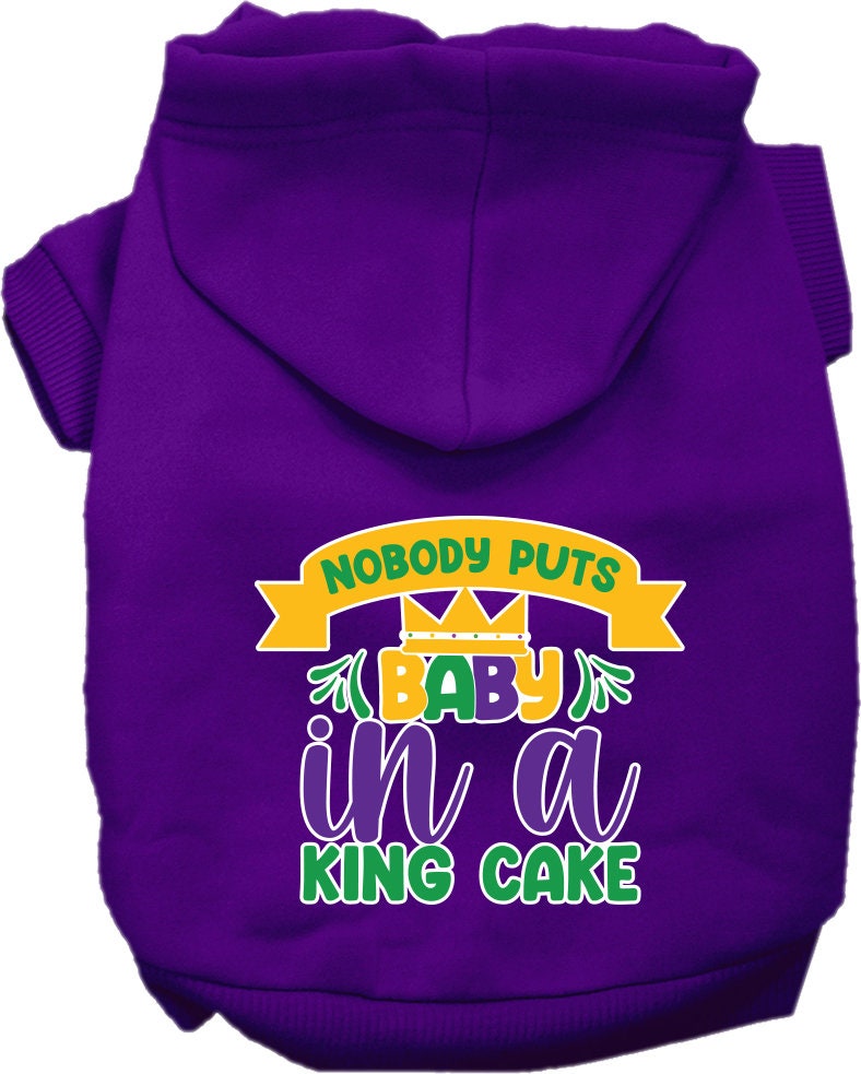 A medium to large pet wearing a soft, warm hoodie with the phrase 'Nobody Puts Baby In A King Cake' printed on it, showcasing its stylish design.
