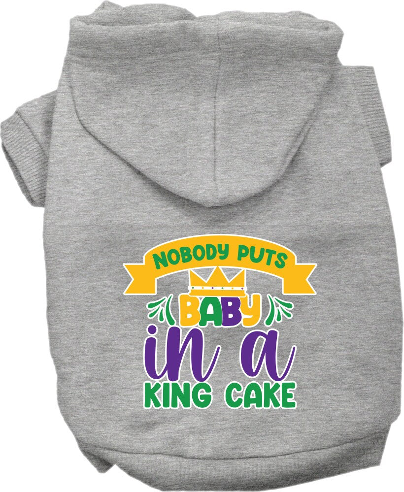 A medium to large pet wearing a soft, warm hoodie with the phrase 'Nobody Puts Baby In A King Cake' printed on it, showcasing its stylish design.