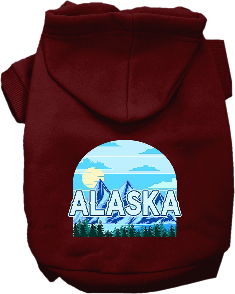 A small to medium pet wearing a cozy Alaska Trailblazer hoodie, showcasing its stylish design and convenient leash access hole.