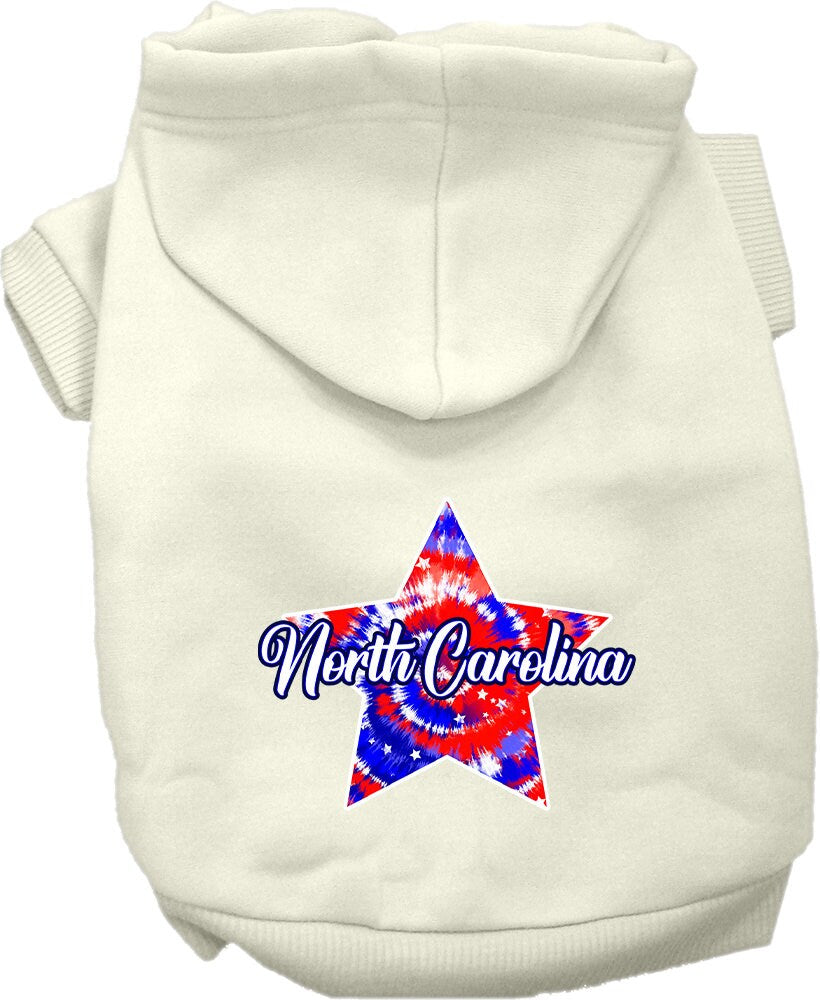 A small to medium pet wearing a colorful North Carolina Patriotic Tie Dye hoodie, showcasing its soft fabric and convenient leash access hole.