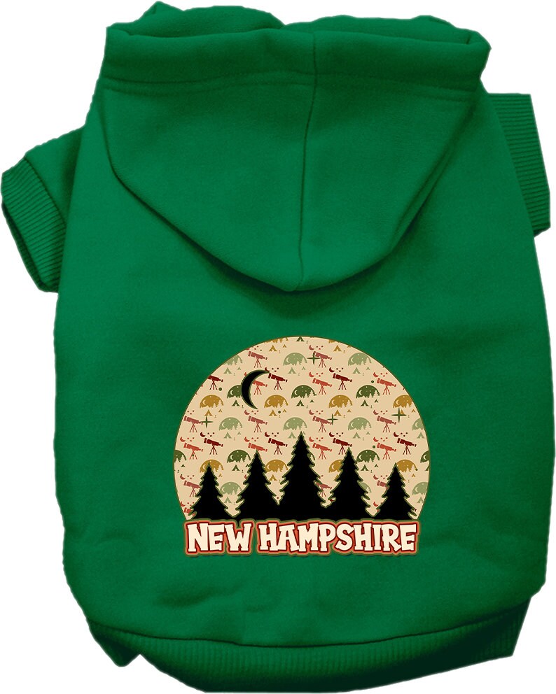 A small to medium pet wearing a cozy screen printed hoodie with a 'New Hampshire Under The Stars' design, showcasing its soft fabric and convenient leash access.