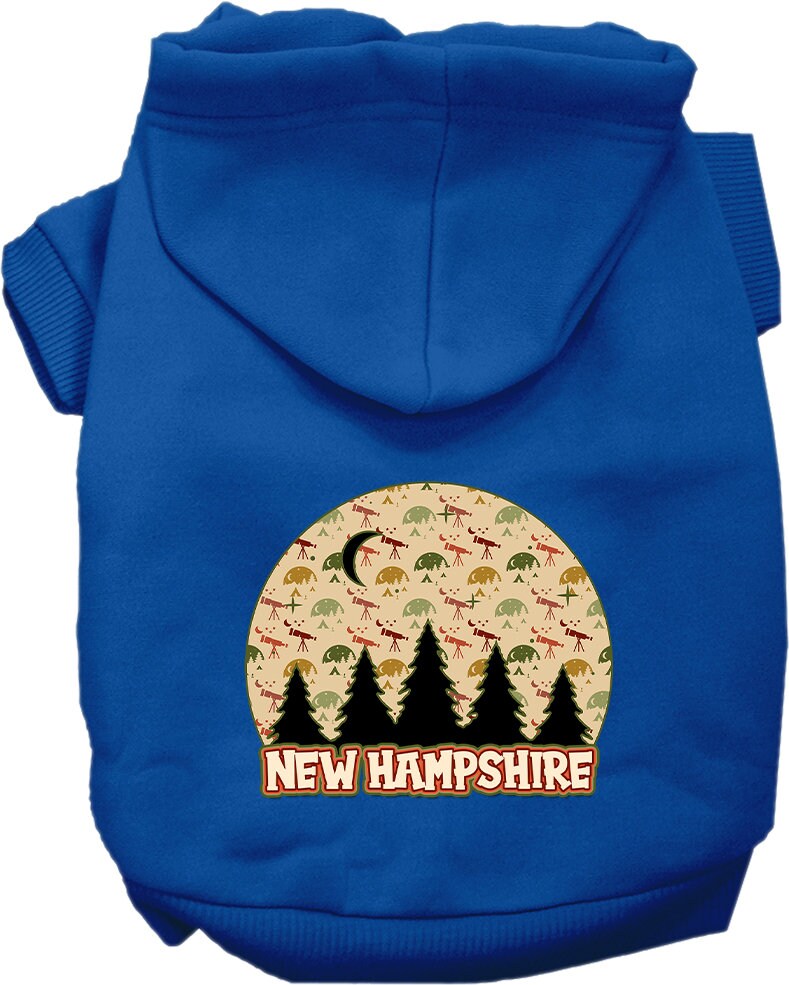 A small to medium pet wearing a cozy screen printed hoodie with a 'New Hampshire Under The Stars' design, showcasing its soft fabric and convenient leash access.