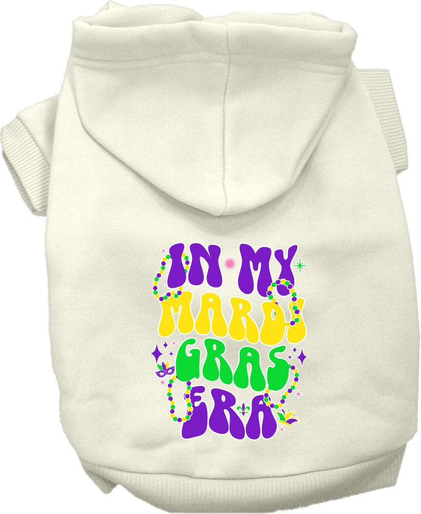 A small to medium pet wearing a colorful screen printed hoodie with the text 'In My Mardi Gras Era', showcasing a festive design.