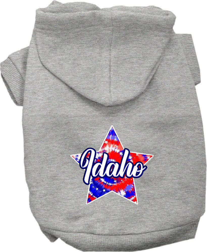 A small to medium pet wearing a colorful Idaho Patriotic Tie Dye hoodie, showcasing its soft fabric and convenient leash access hole.