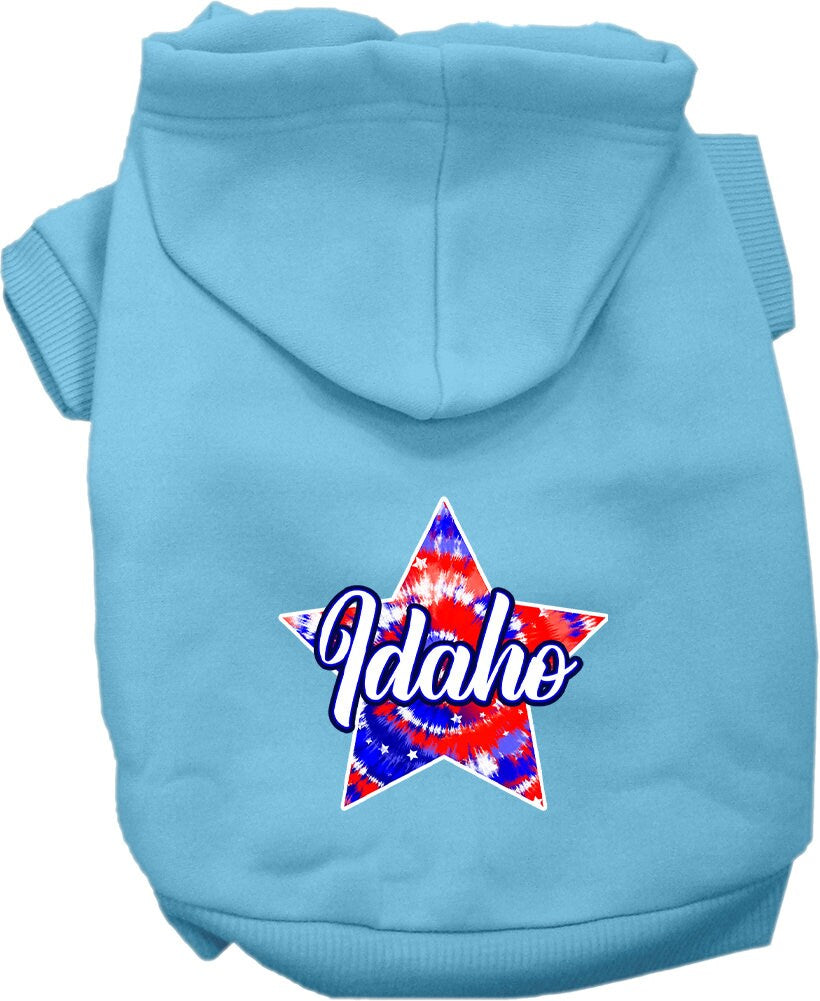 A small to medium pet wearing a colorful Idaho Patriotic Tie Dye hoodie, showcasing its soft fabric and convenient leash access hole.