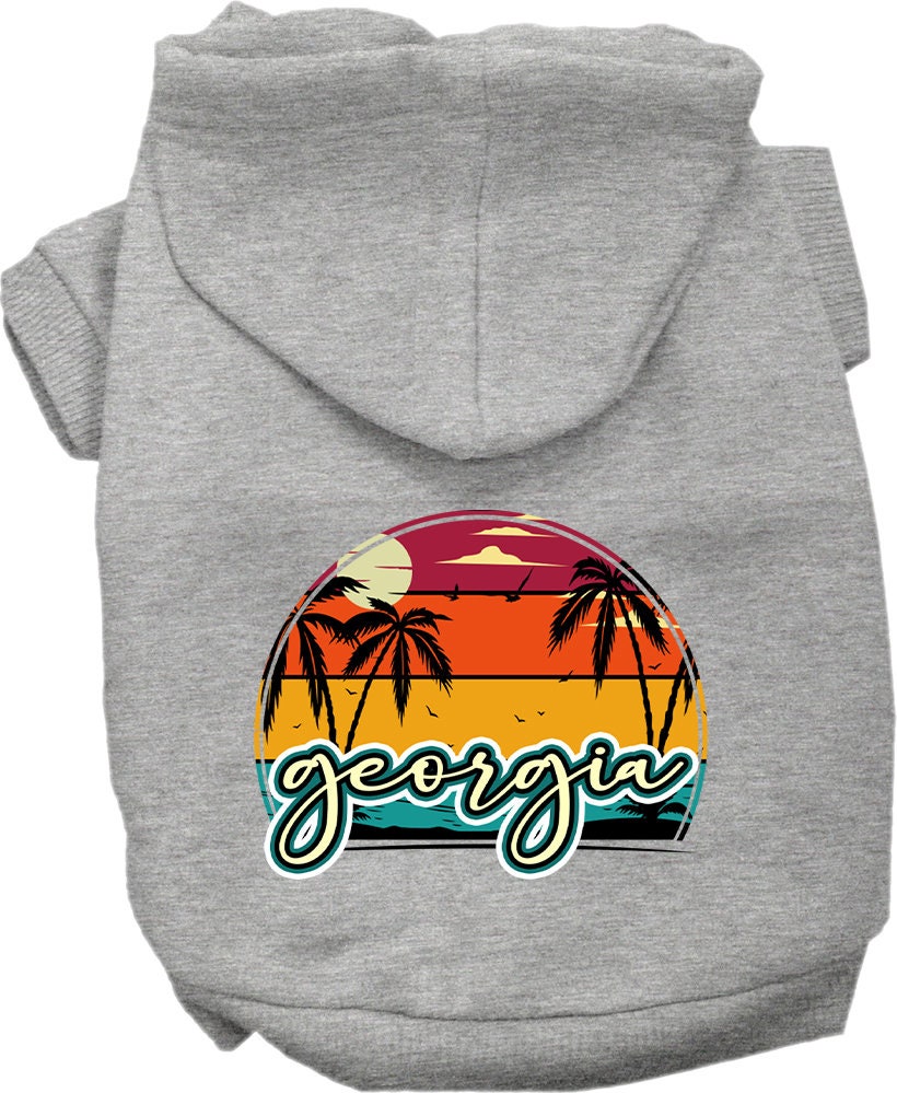 A small to medium pet wearing a stylish Georgia Retro Beach Sunset hoodie, showcasing its vibrant colors and comfortable fit.