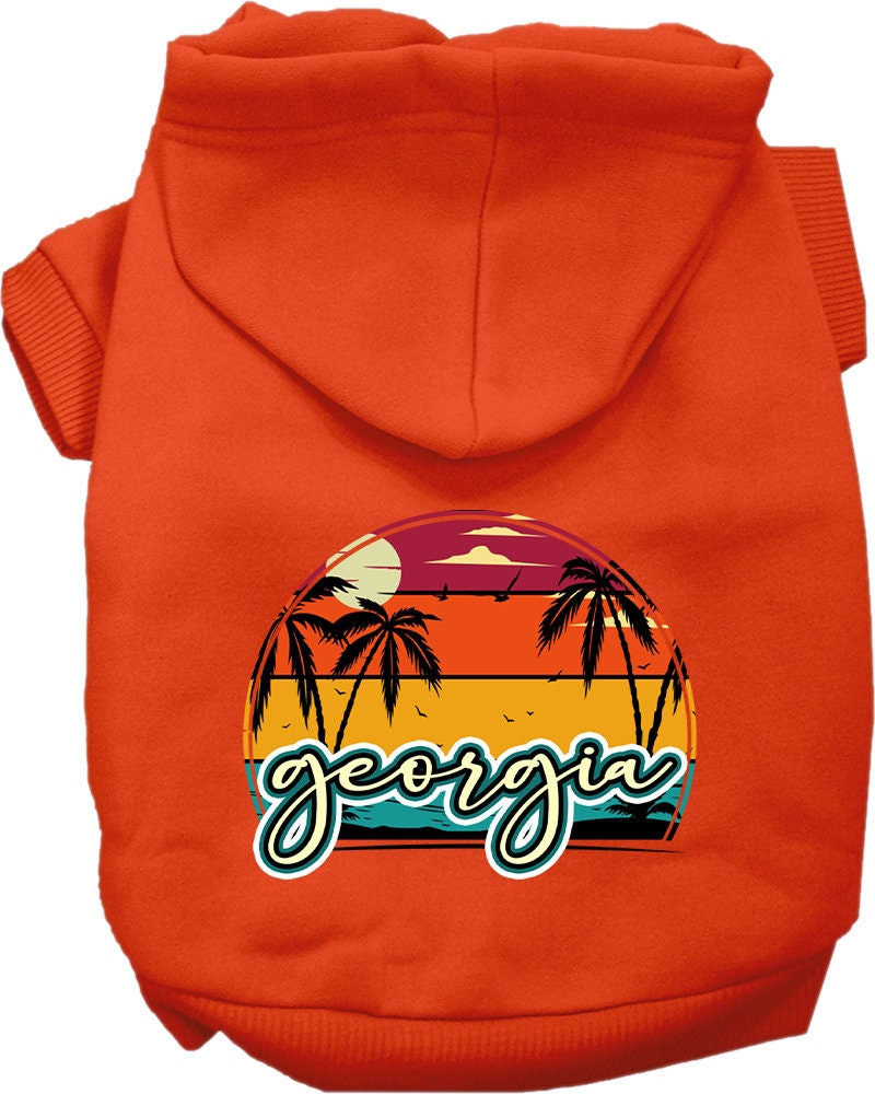 A small to medium pet wearing a stylish Georgia Retro Beach Sunset hoodie, showcasing its vibrant colors and comfortable fit.