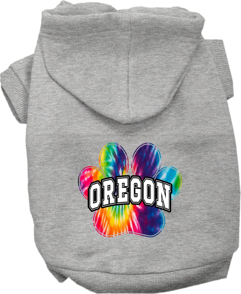 A small to medium pet wearing a vibrant Oregon Bright Tie Dye hoodie, showcasing its soft fabric and convenient leash access hole.