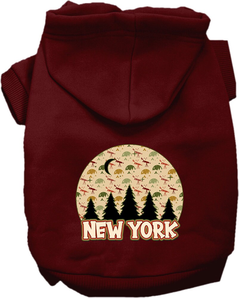 A small to medium pet wearing a stylish screen printed hoodie with a 'New York Under The Stars' design, showcasing its soft fabric and convenient leash access hole.
