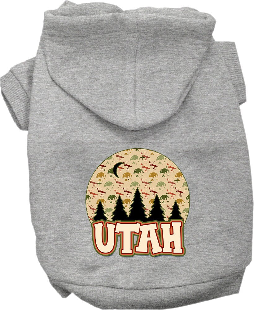 A small to medium pet wearing a cozy screen printed hoodie with a 'Utah Under The Stars' design, showcasing its soft fabric and convenient leash access.