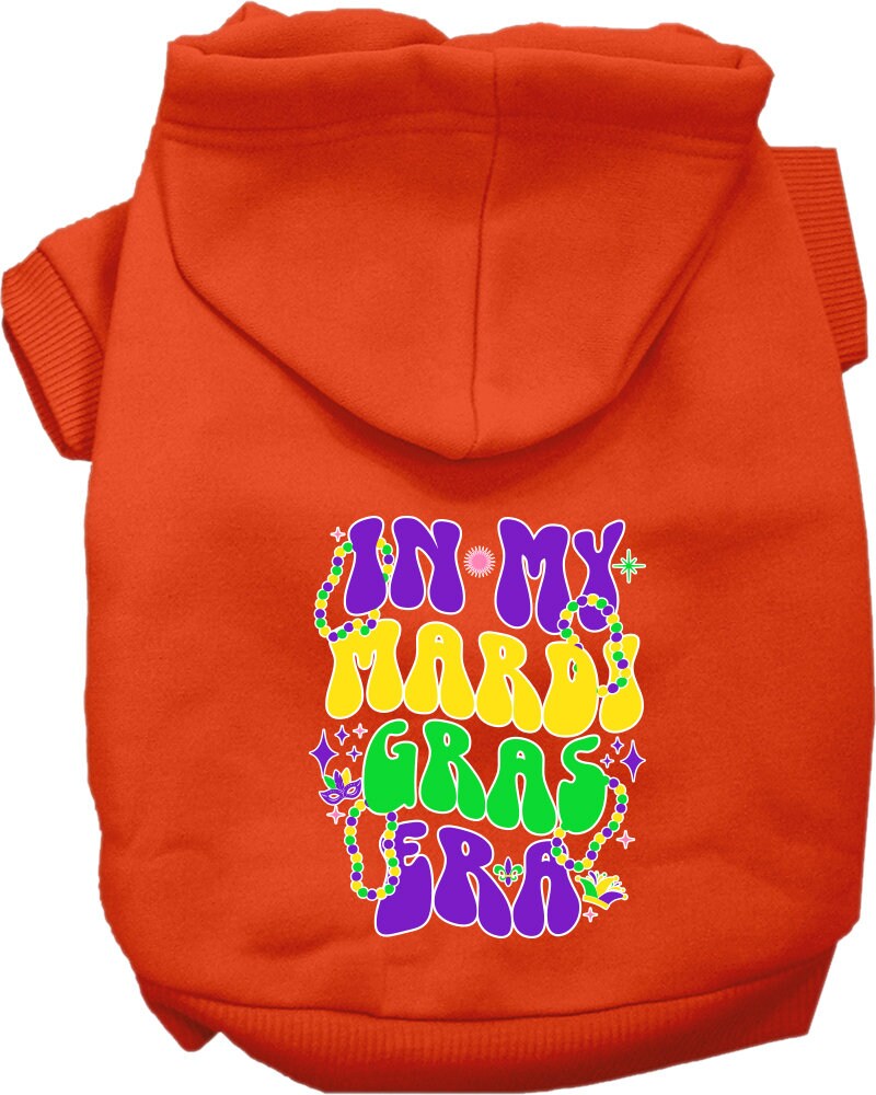 A small to medium pet wearing a colorful screen printed hoodie that says 'In My Mardi Gras Era', showcasing a festive design.