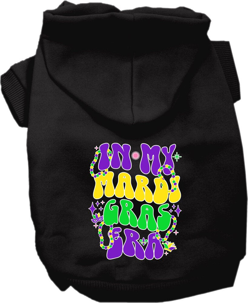 A small to medium pet wearing a colorful screen printed hoodie that says 'In My Mardi Gras Era', showcasing a festive design.