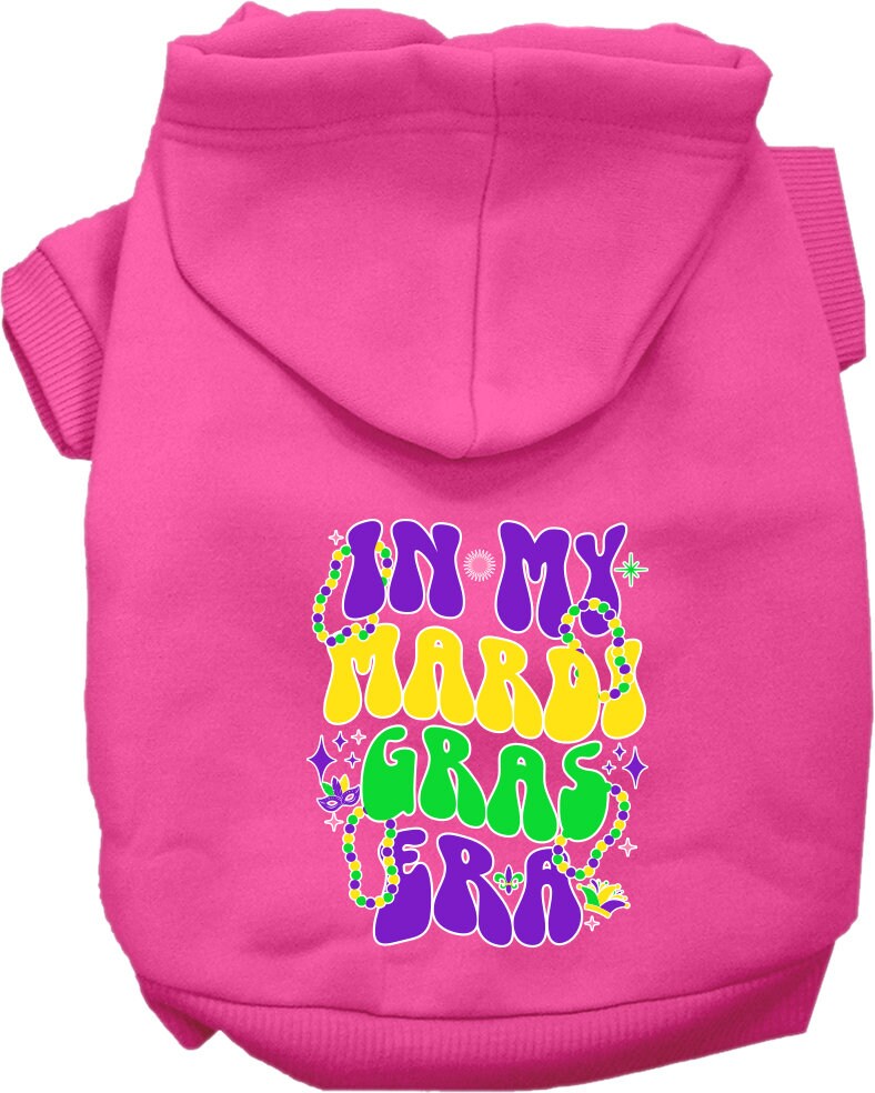 A small to medium pet wearing a colorful screen printed hoodie that says 'In My Mardi Gras Era', showcasing a festive design.