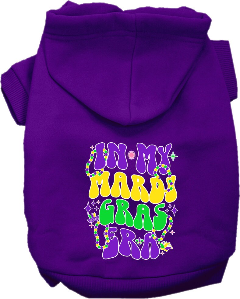 A small to medium pet wearing a colorful screen printed hoodie that says 'In My Mardi Gras Era', showcasing a festive design.