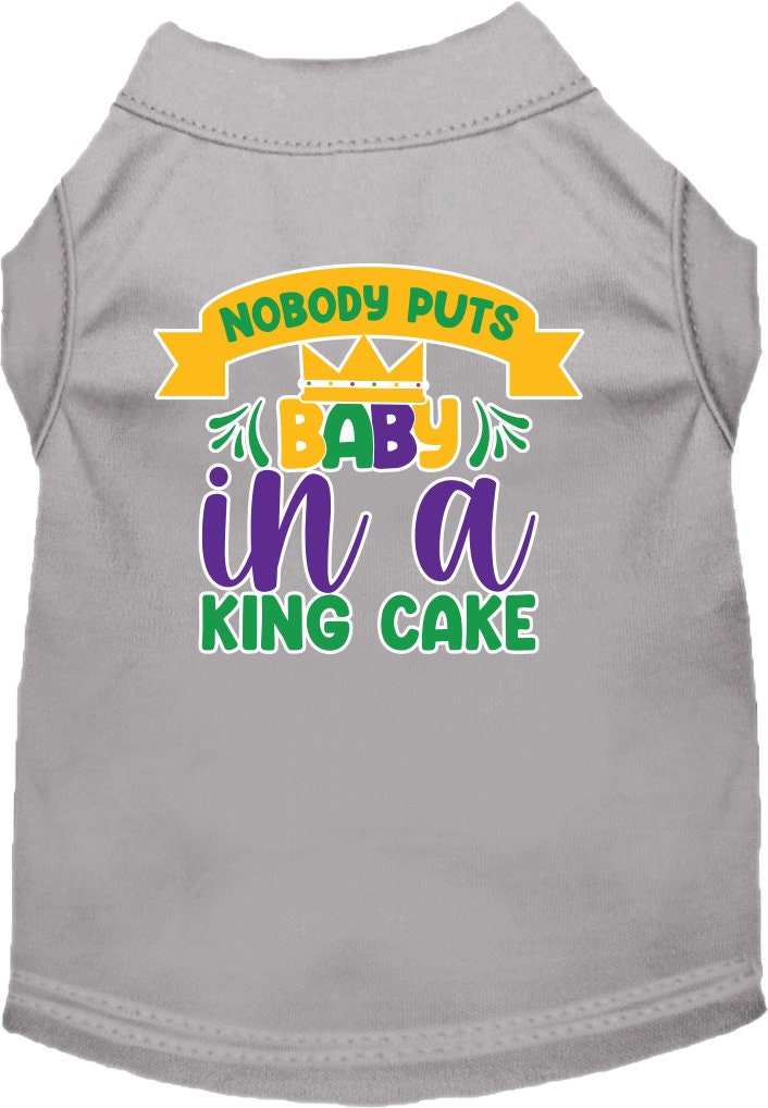 A small to medium pet wearing a soft, screen printed shirt with the phrase 'Nobody Puts Baby In A King Cake', showcasing its unique design and comfortable fit.