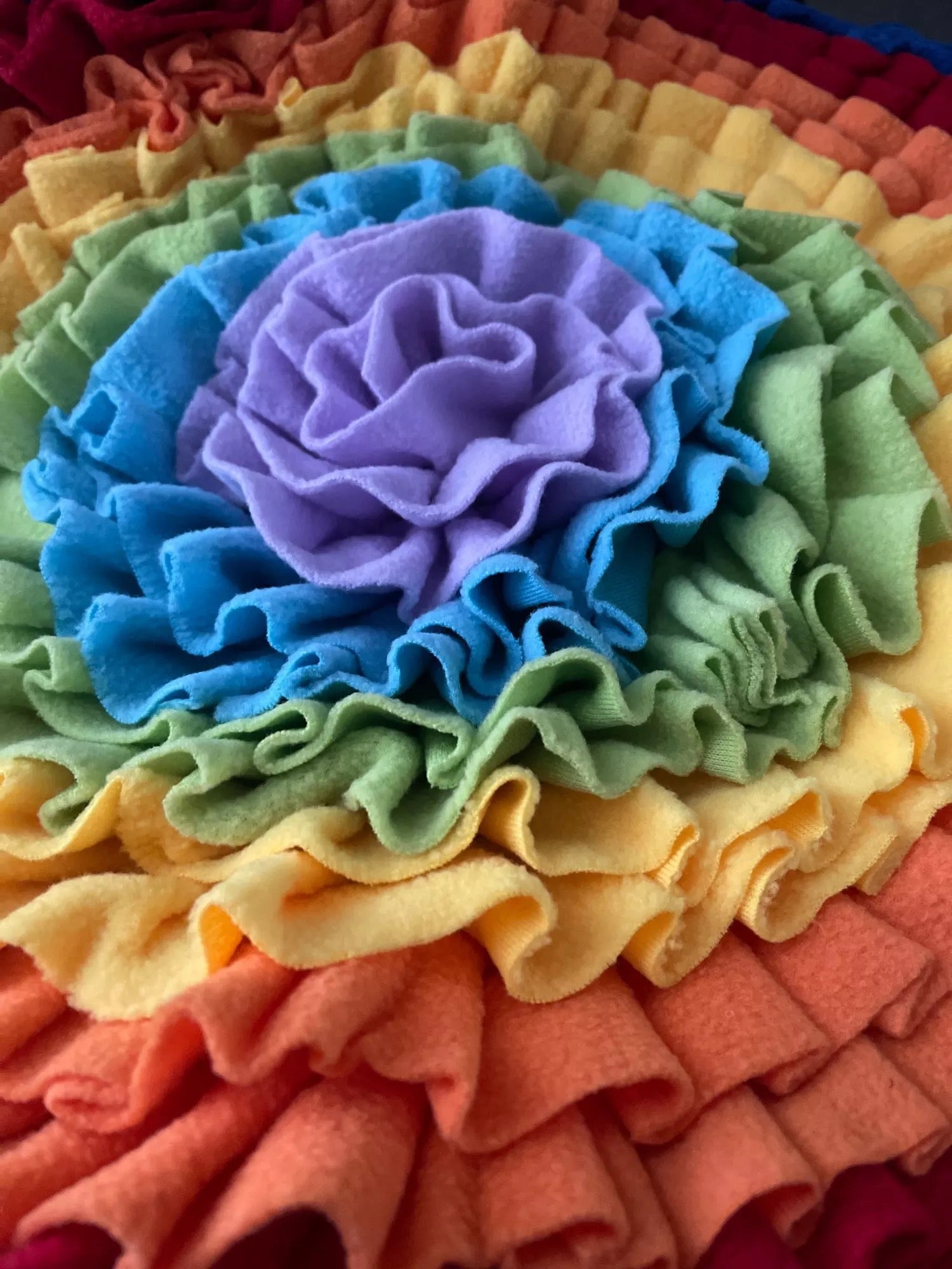 A colorful snuffle mat designed for pets, featuring various textures and hiding spots for treats, promoting mental stimulation and slow feeding.