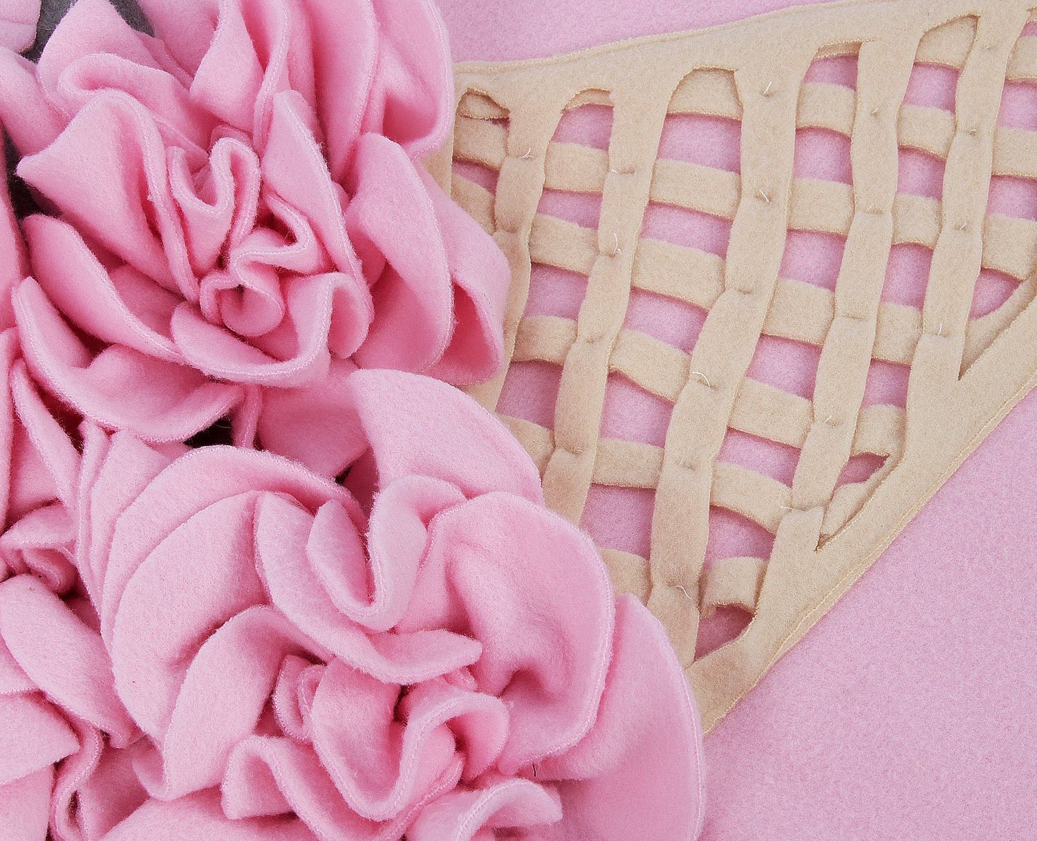 A colorful pink ice cream-shaped snuffle mat designed for pets, featuring various textures for hiding treats and encouraging foraging behavior.
